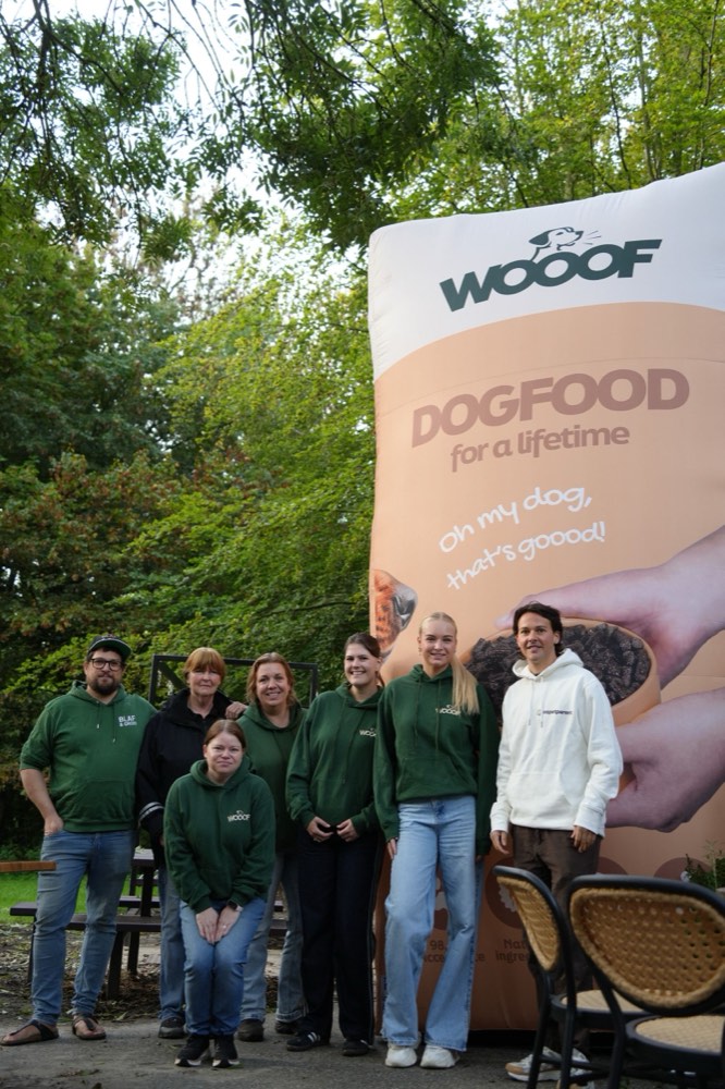 Het WOOOF-team in groene hoodies voor de grote WOOOF-zak